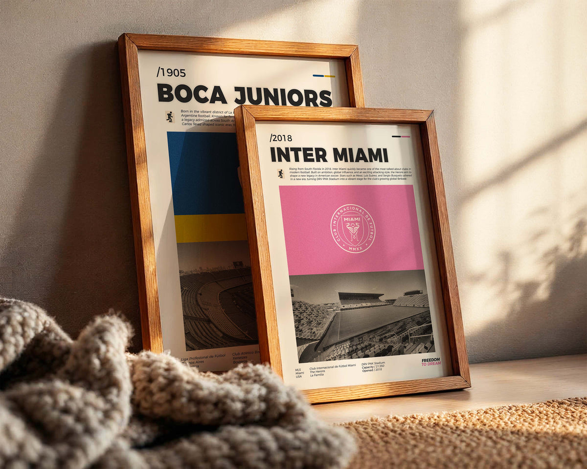 Deux posters de clubs de football encadrés et posés contre un mur dans un intérieur moderne.