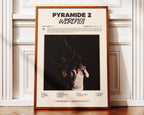 Poster minimaliste encadré de Werenoi Pyramide 2 posé contre un mur bien visible, décoration rap contemporain.