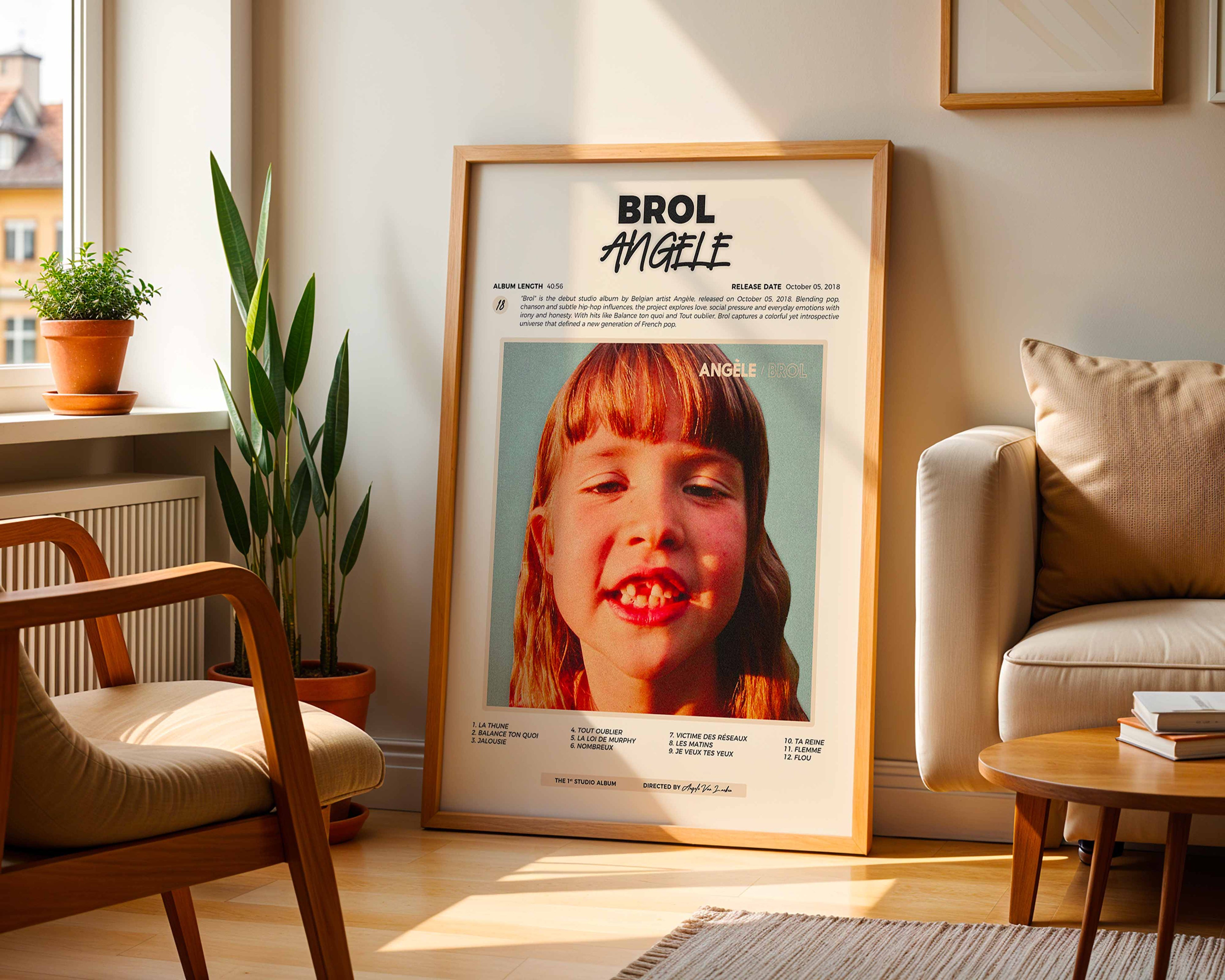 Poster minimaliste encadré de l'album de Angèle posé contre un mur dans un salon lumineux, art mural contemporain.