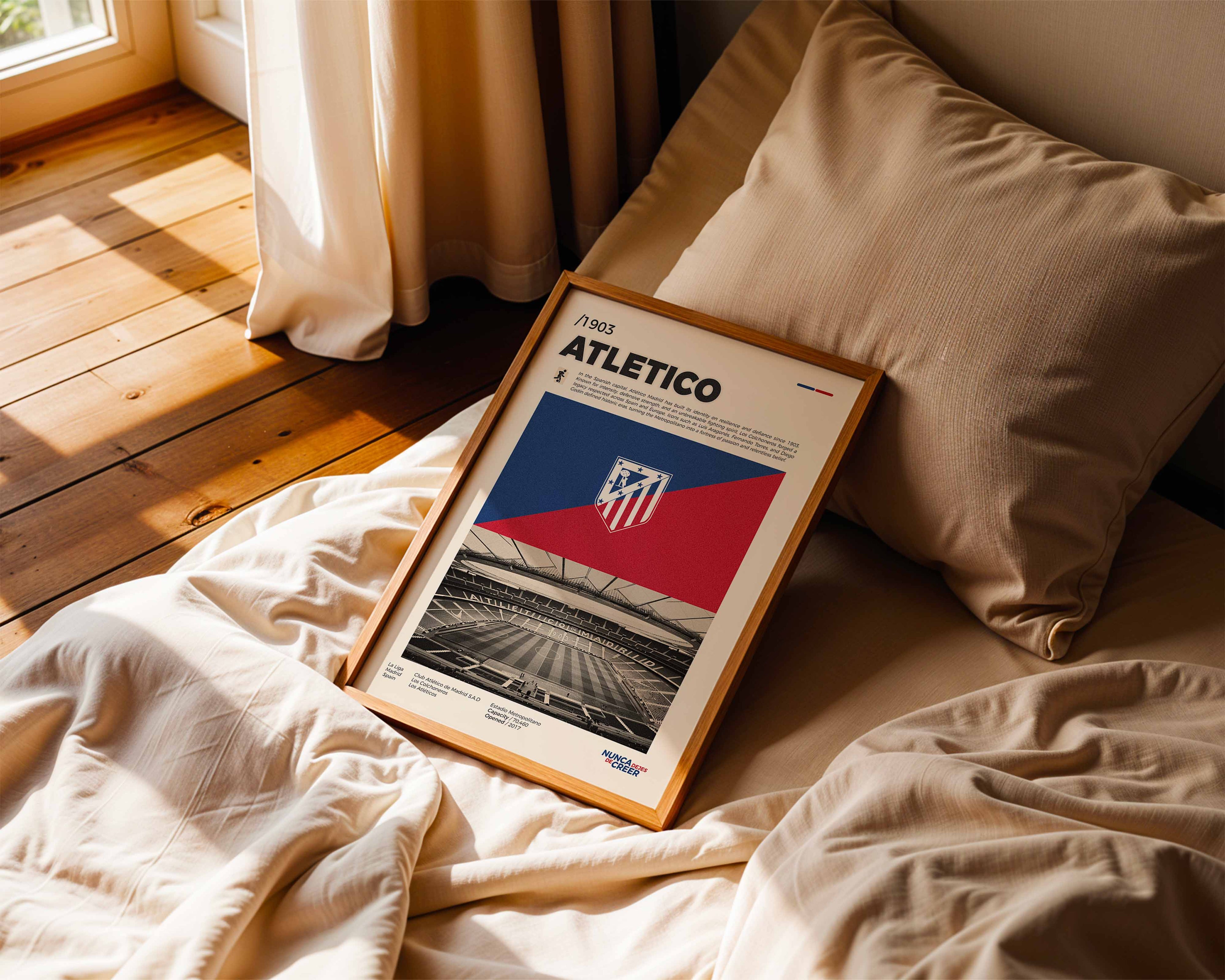 Poster minimaliste encadré du club Atletico de Madrid posé contre un mur dans un salon lumineux, art mural contemporain.