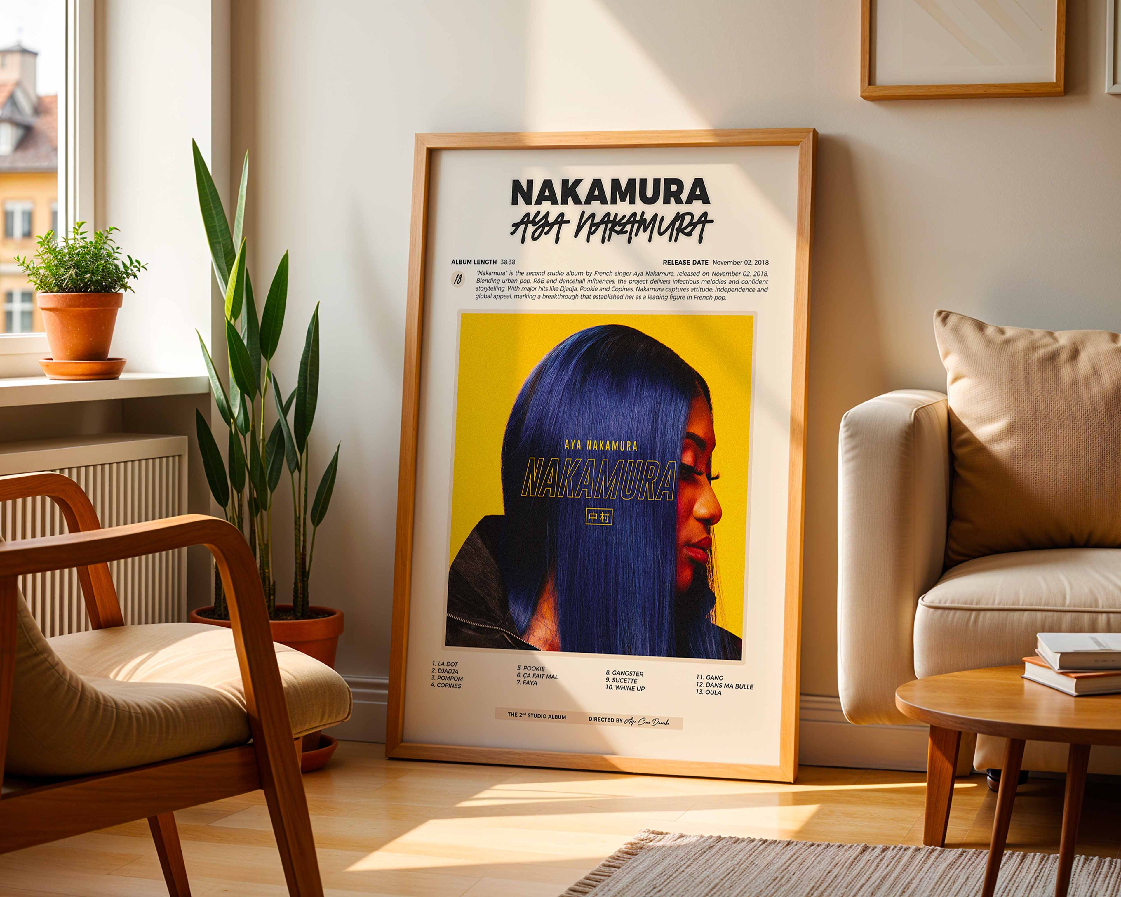 Poster minimaliste encadré de l'album de Aya Nakamura posé contre un mur dans un salon lumineux, art mural contemporain.