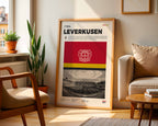 Poster minimaliste du club de Leverkusen posé contre un mur dans un salon lumineux, art mural BayArena.