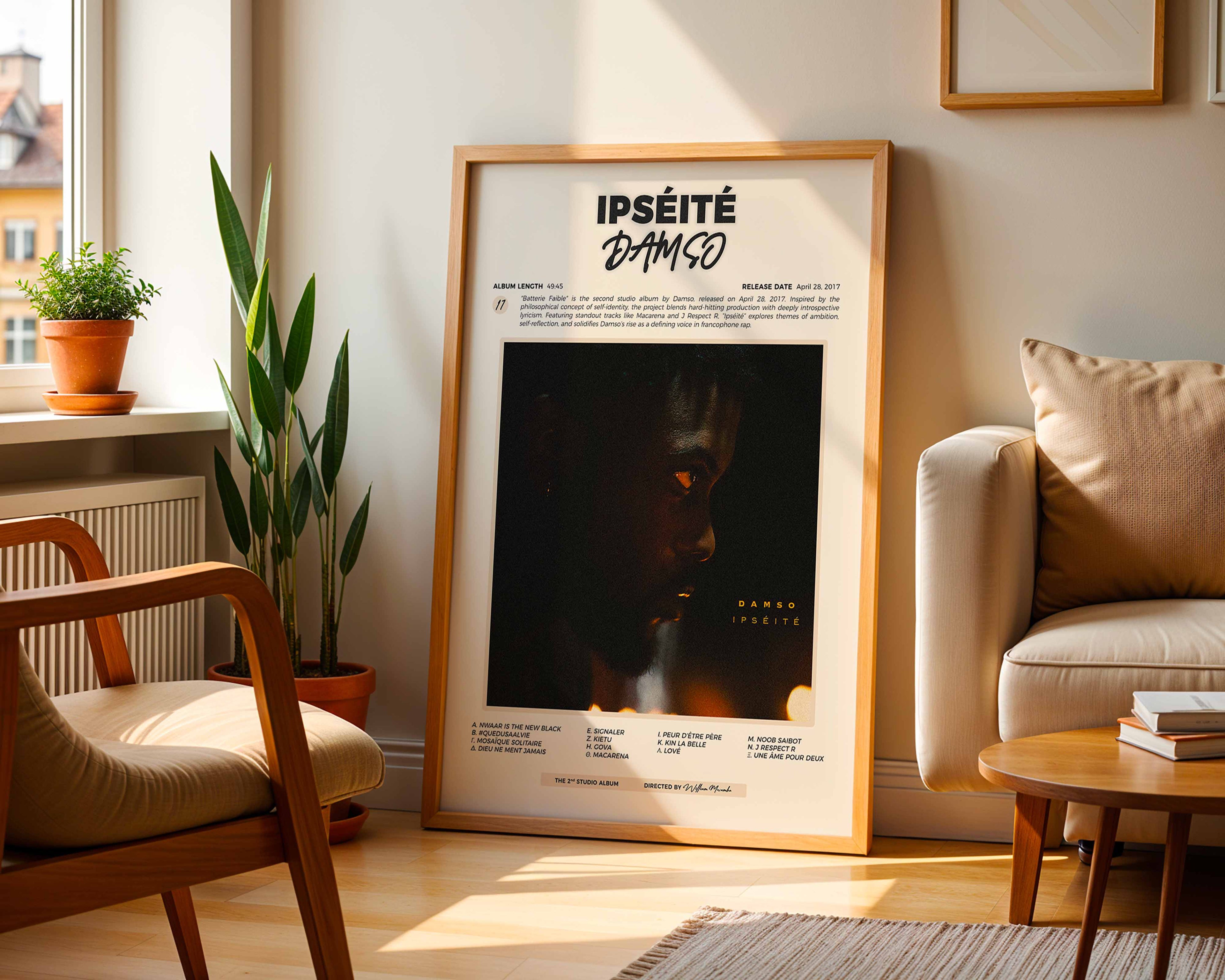Poster minimaliste encadré de l'album de Damso posé contre un mur dans un salon lumineux, art mural contemporain.