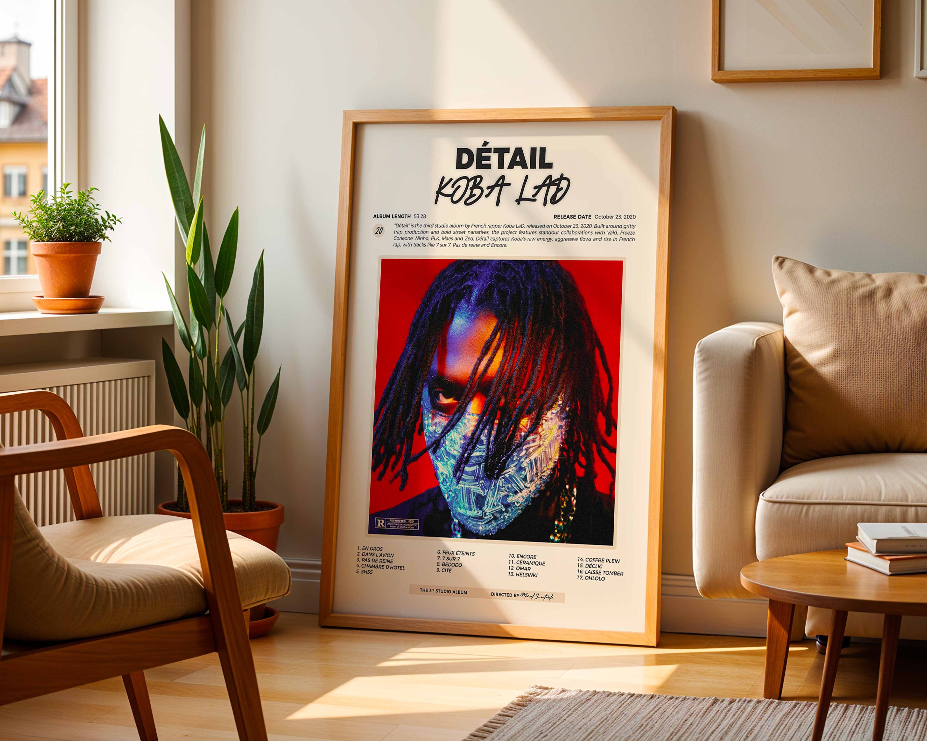 Poster minimaliste encadré de l'album de Koba LaD posé contre un mur dans un salon lumineux, art mural contemporain.