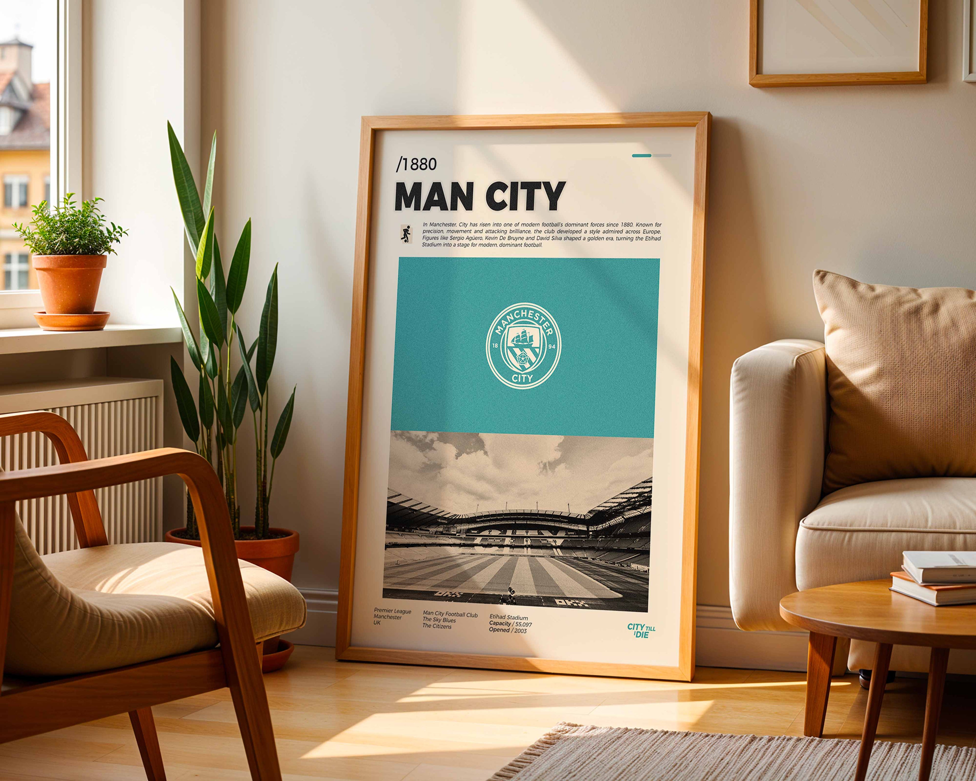 Poster minimaliste encadré du club Manchester City posé contre un mur dans un salon lumineux, art mural de football Premier League.