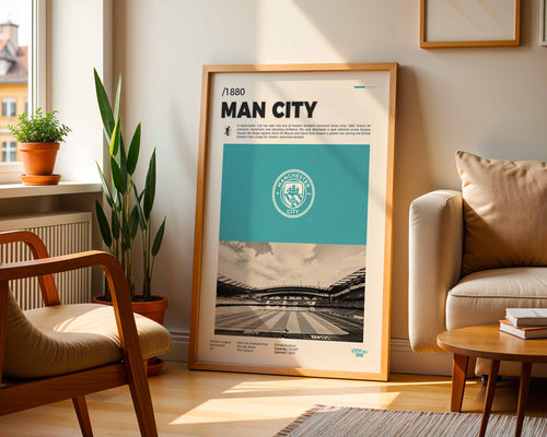 Poster minimaliste encadré du club Manchester City posé contre un mur dans un salon lumineux, art mural de football Premier League.
