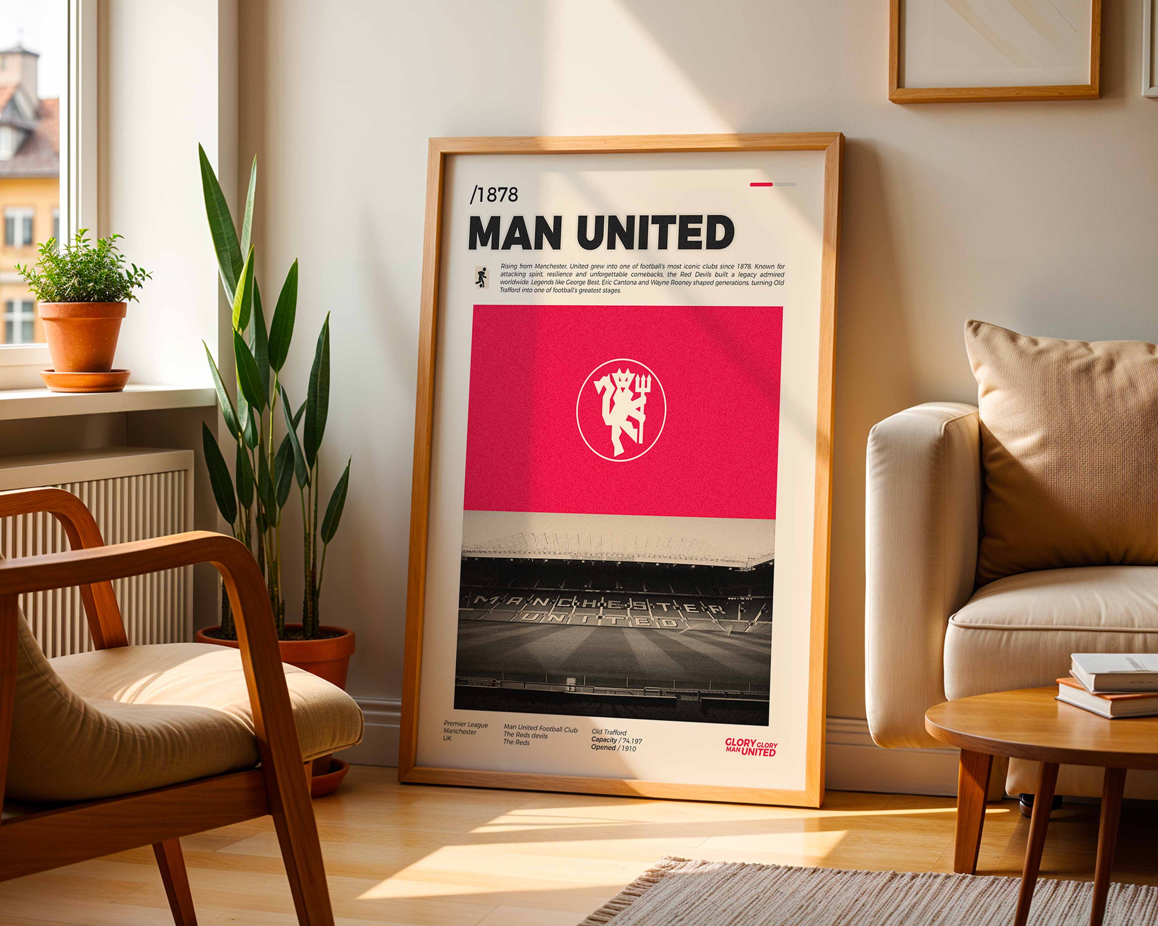 Poster minimaliste encadré du club Manchester United posé contre un mur dans un salon lumineux, art mural de football Premier League.