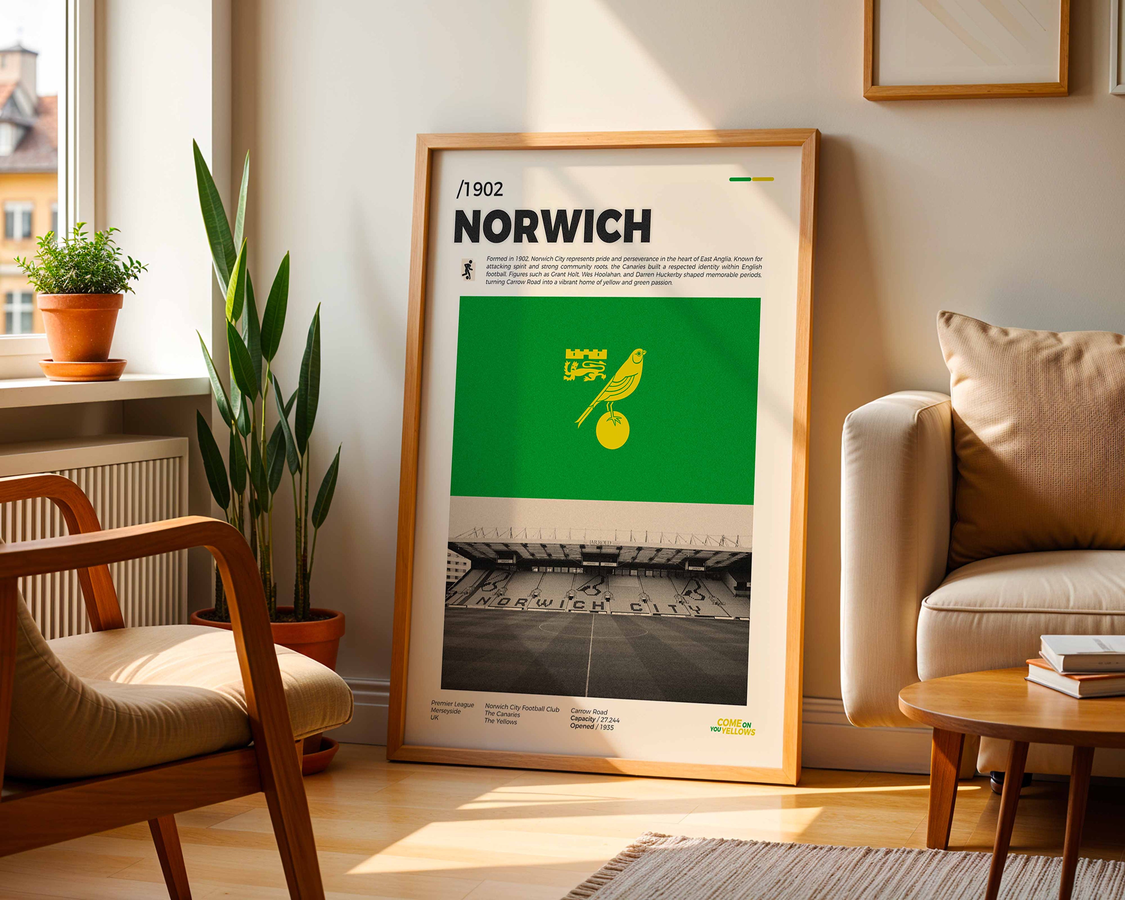 Poster minimaliste du club de Norwich posé contre un mur dans un salon lumineux, art mural Carrow Road.