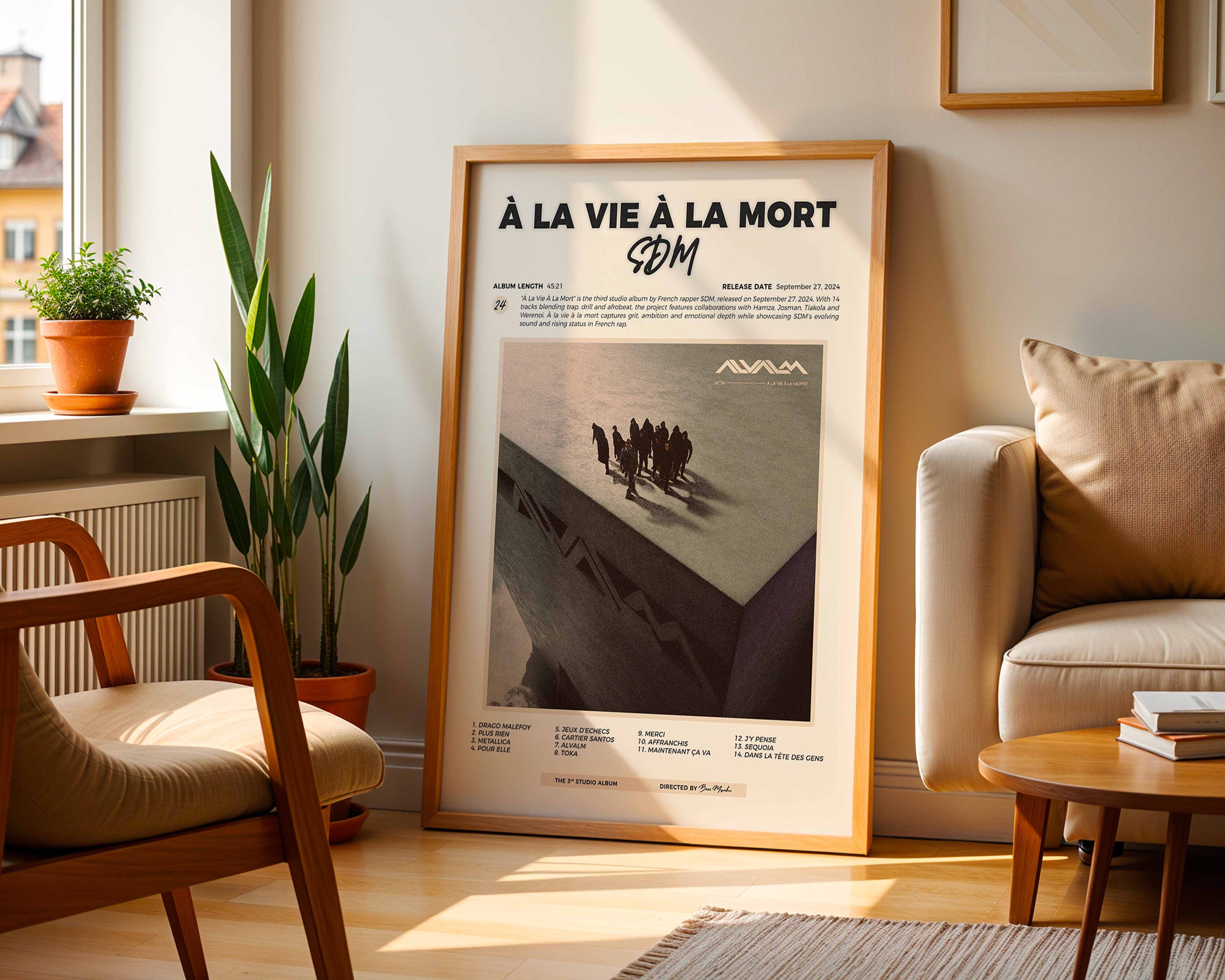 Poster minimaliste encadré de l'album de SDM posé contre un mur dans un salon lumineux, art mural contemporain.