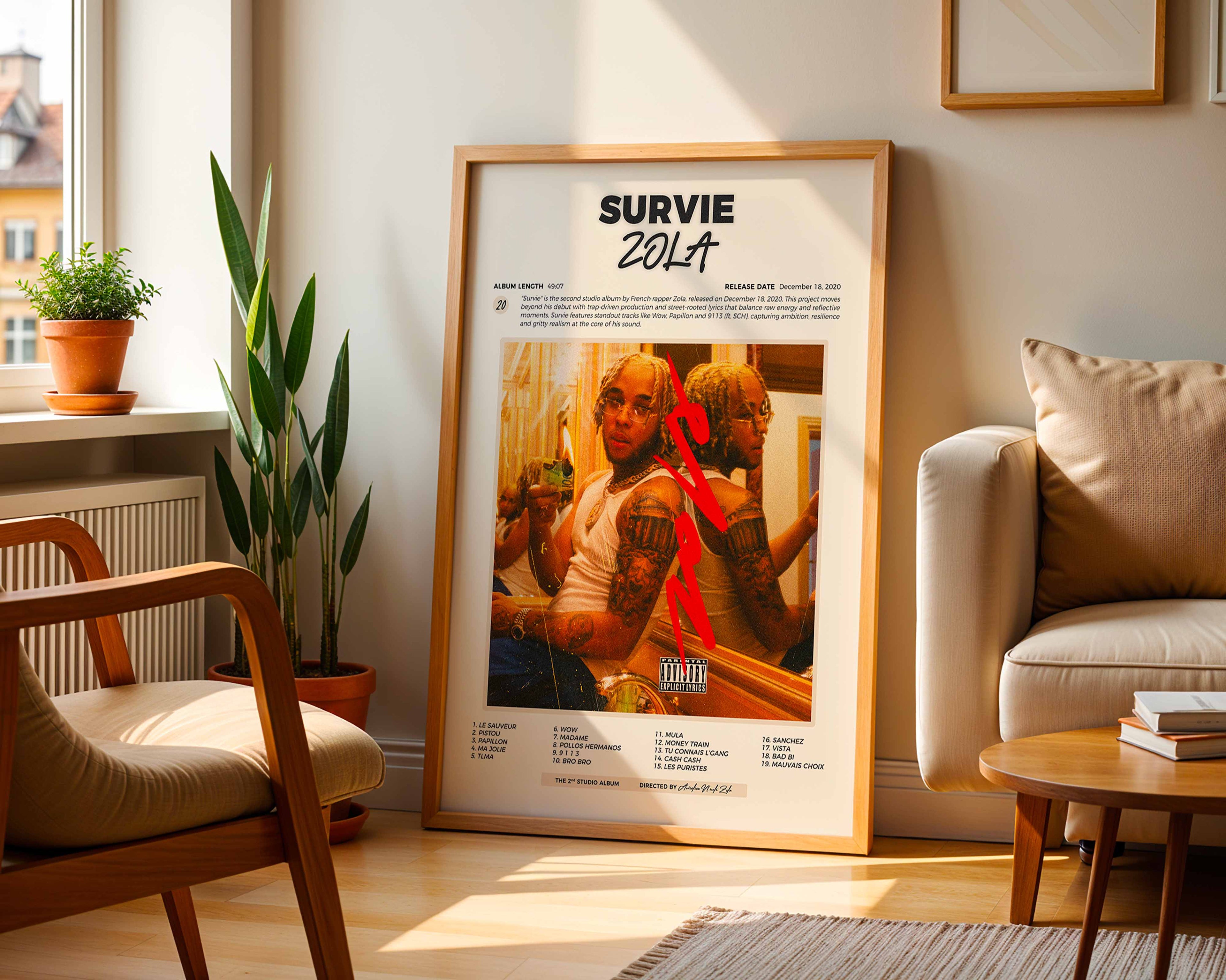 Poster minimaliste encadré de l'album Survie de Zola posé contre un mur dans un salon lumineux, art mural contemporain.