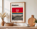 Poster minimaliste encadré d'Arsenal FC accroché au mur dans un salon lumineux et bien visible, design premium rouge.