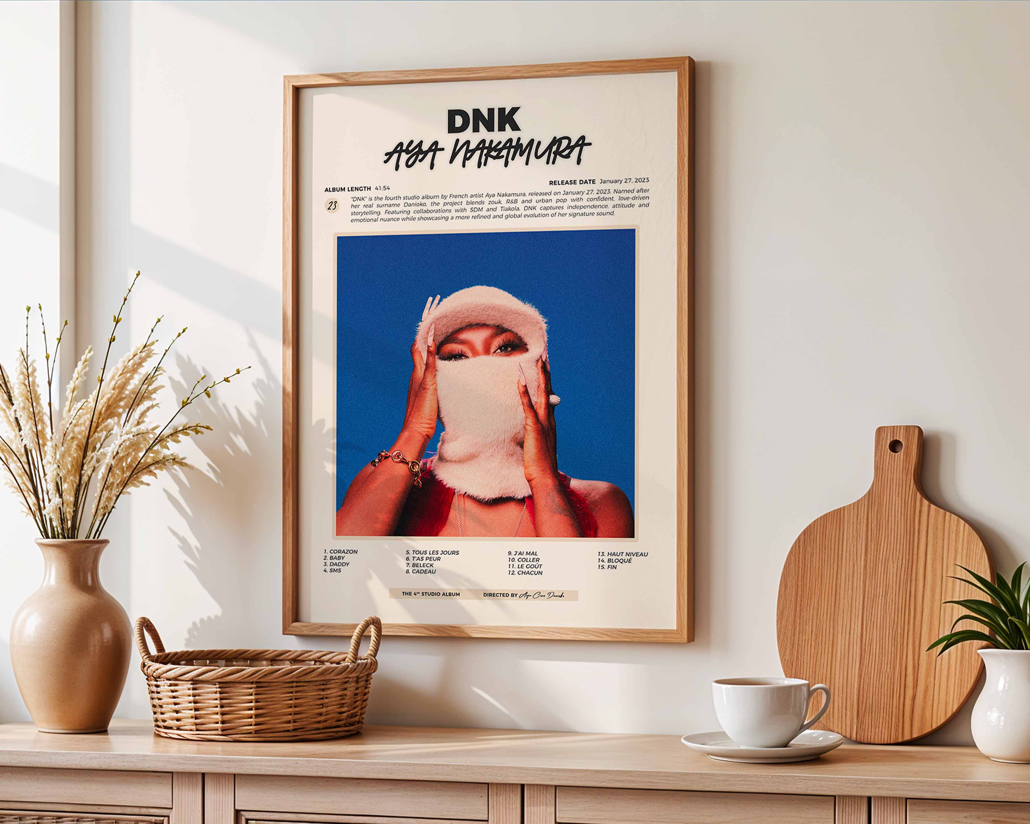 Poster minimaliste encadré de l'album DNK accroché au mur dans un salon lumineux et bien visible, design premium.