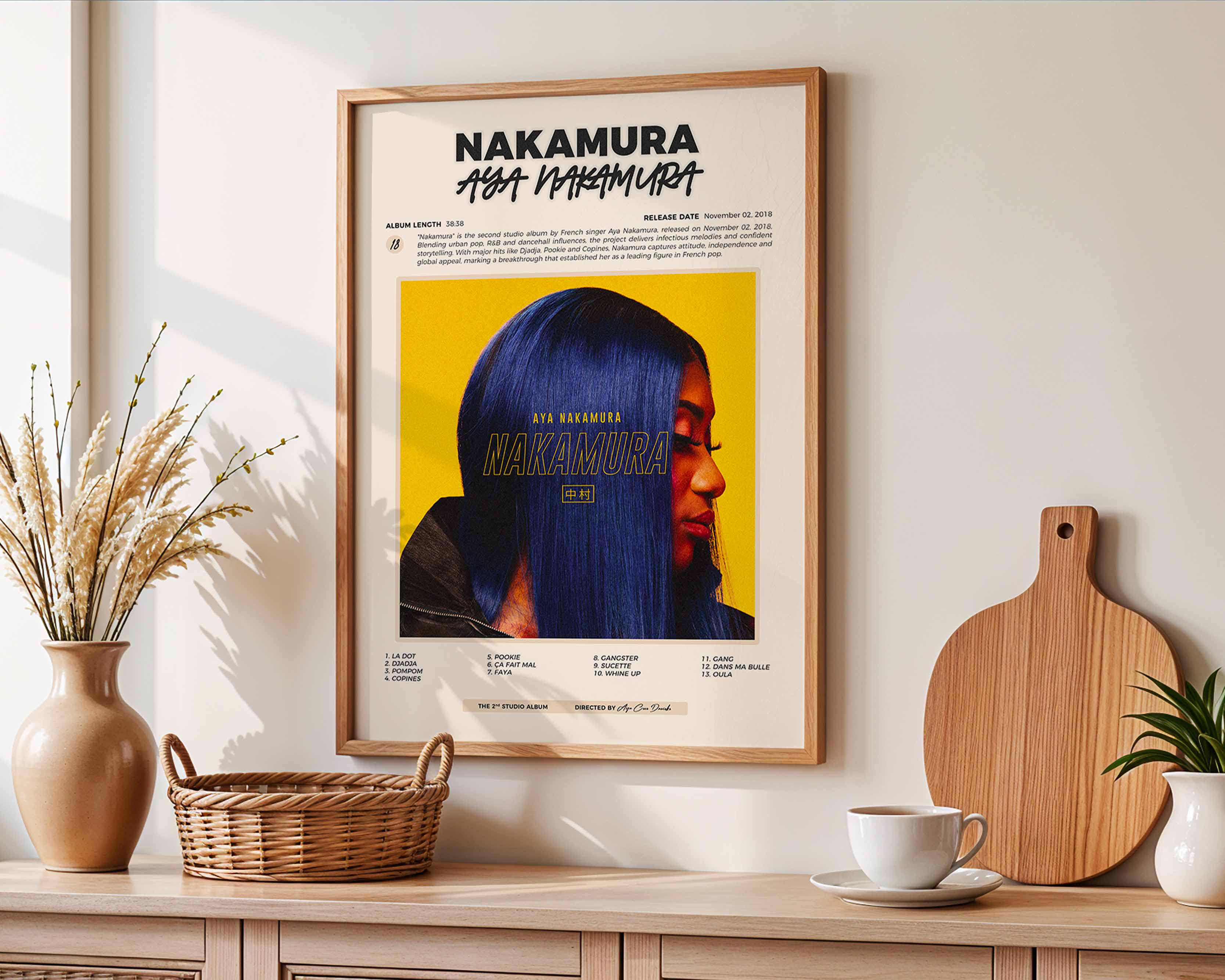 Poster minimaliste encadré de l'album Nakamura accroché au mur dans un salon lumineux et bien visible, design premium.