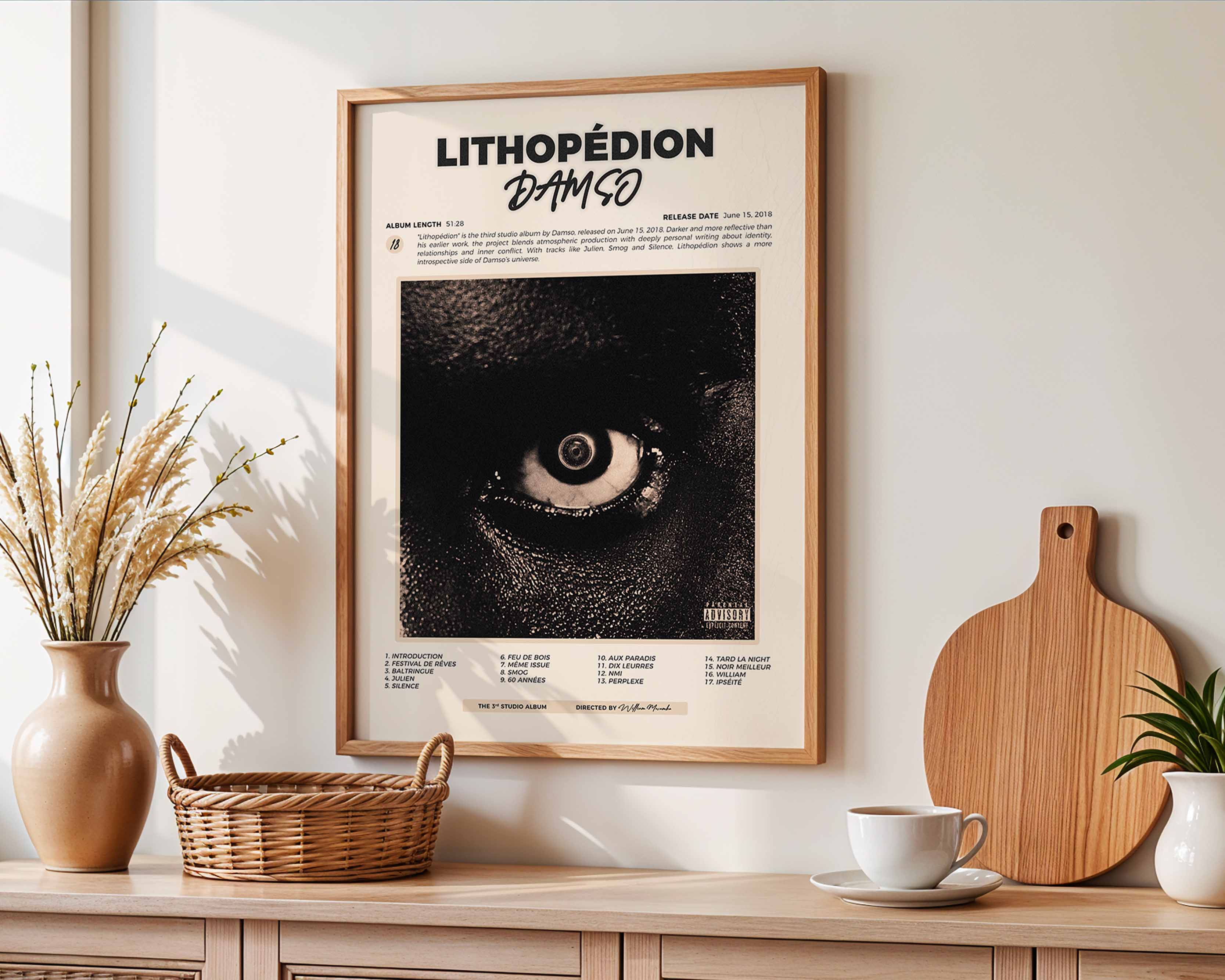Poster minimaliste encadré de l'album Lithopédion accroché au mur dans un salon lumineux et bien visible, design premium.