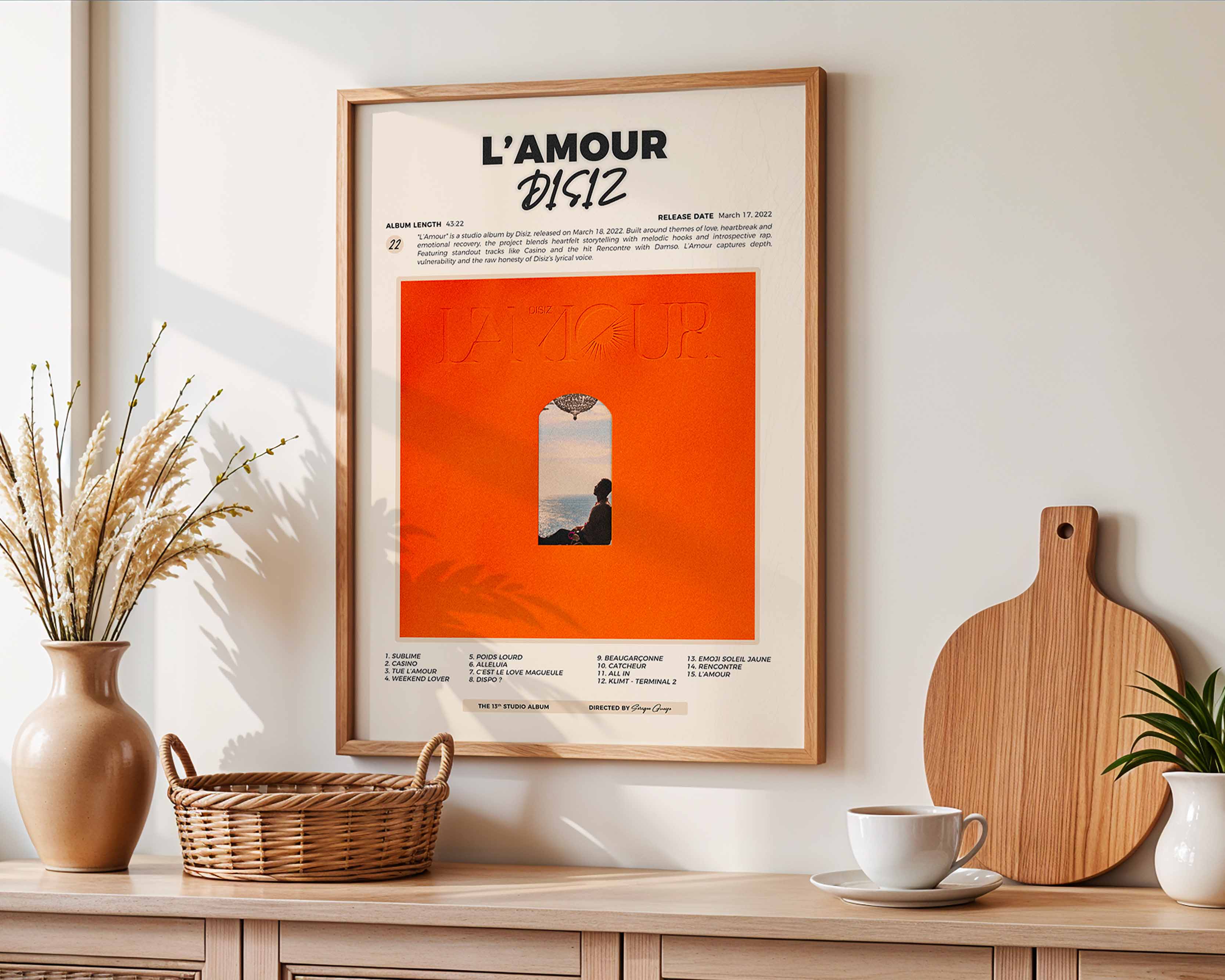 Poster minimaliste encadré de l'album L'Amour accroché au mur dans un salon lumineux et bien visible, design premium.