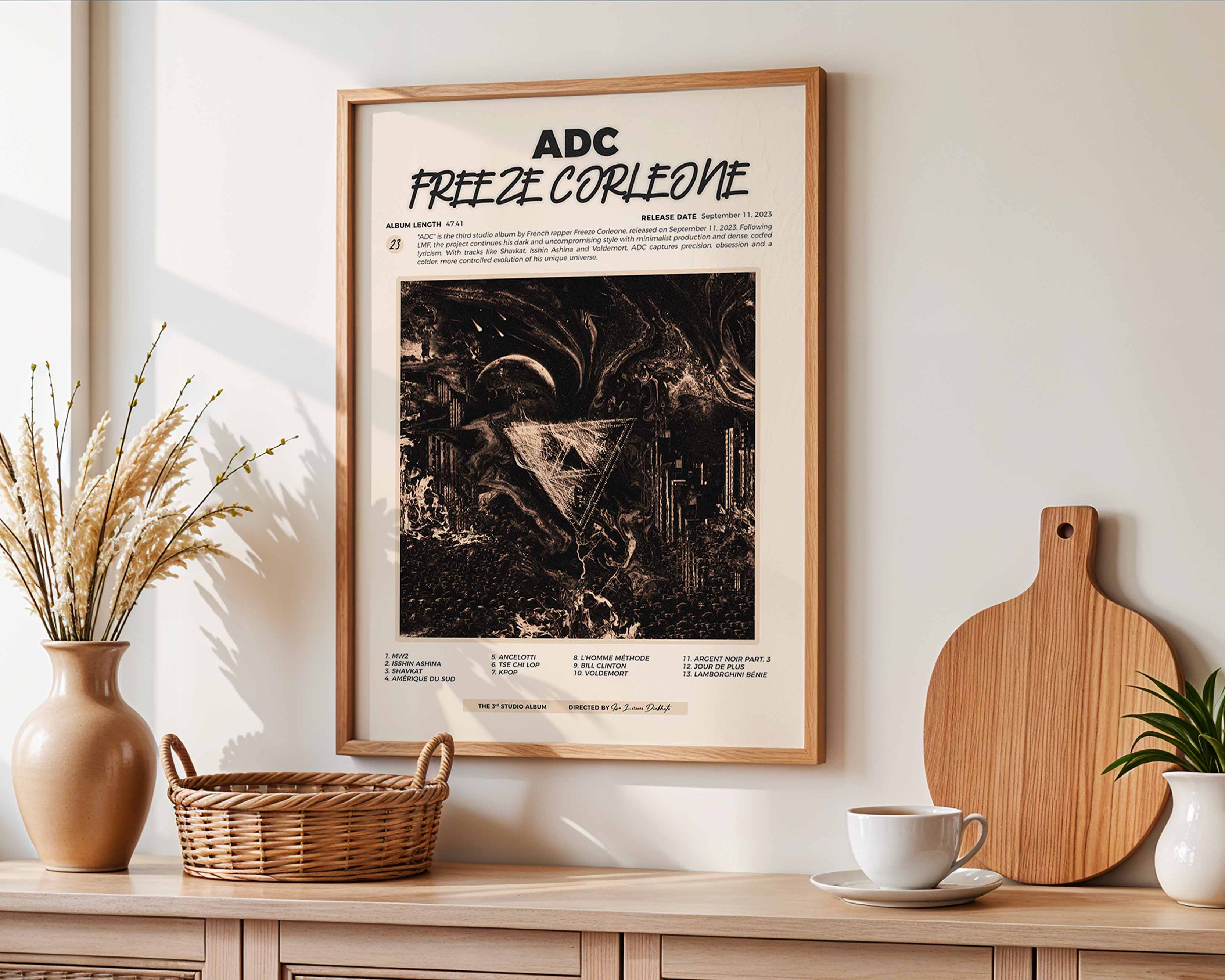 Poster minimaliste encadré de l'album ADC accroché au mur dans un salon lumineux et bien visible, design premium.