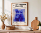 Poster minimaliste encadré de l'album La Melo est Gangx accroché au mur dans un salon lumineux et bien visible, design premium.