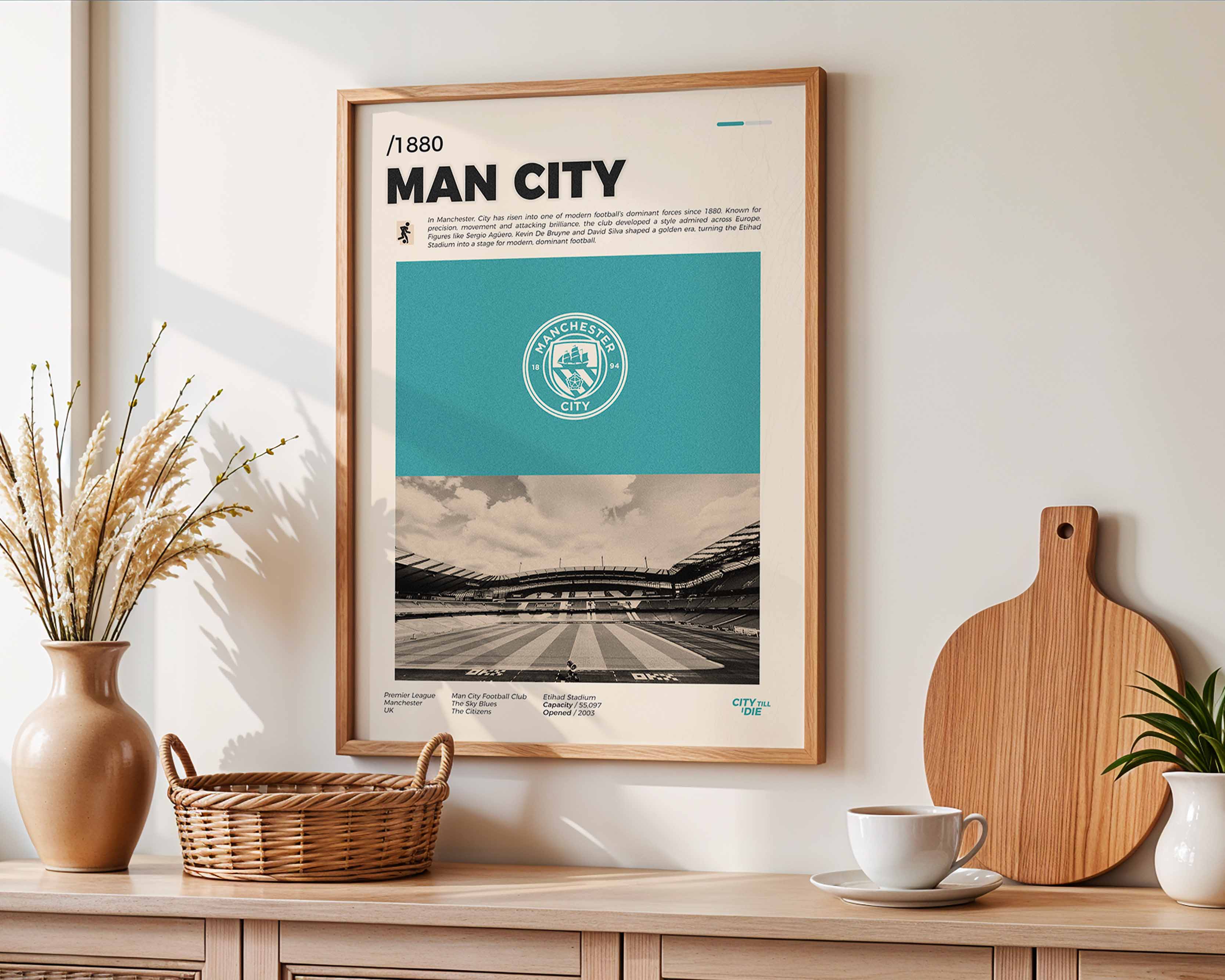 Poster minimaliste encadré de Manchester City accroché au mur dans un salon lumineux et bien visible, design premium bleu ciel.