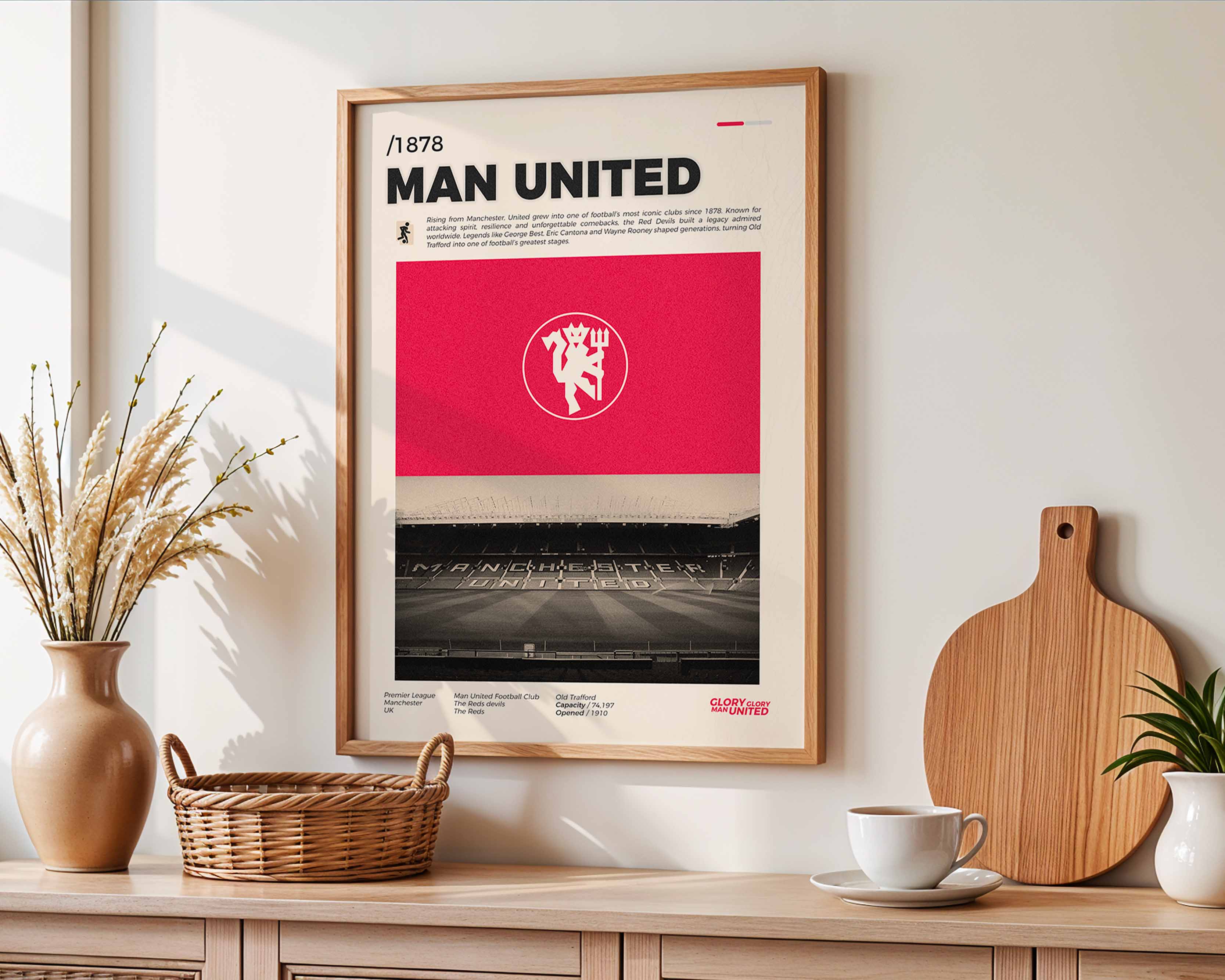 Poster minimaliste encadré de Manchester United accroché au mur dans un salon lumineux et bien visible, design premium rouge.