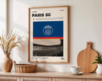 Poster minimaliste encadré du Paris Saint-Germain accroché au mur dans un salon lumineux et bien visible, design premium bleu.