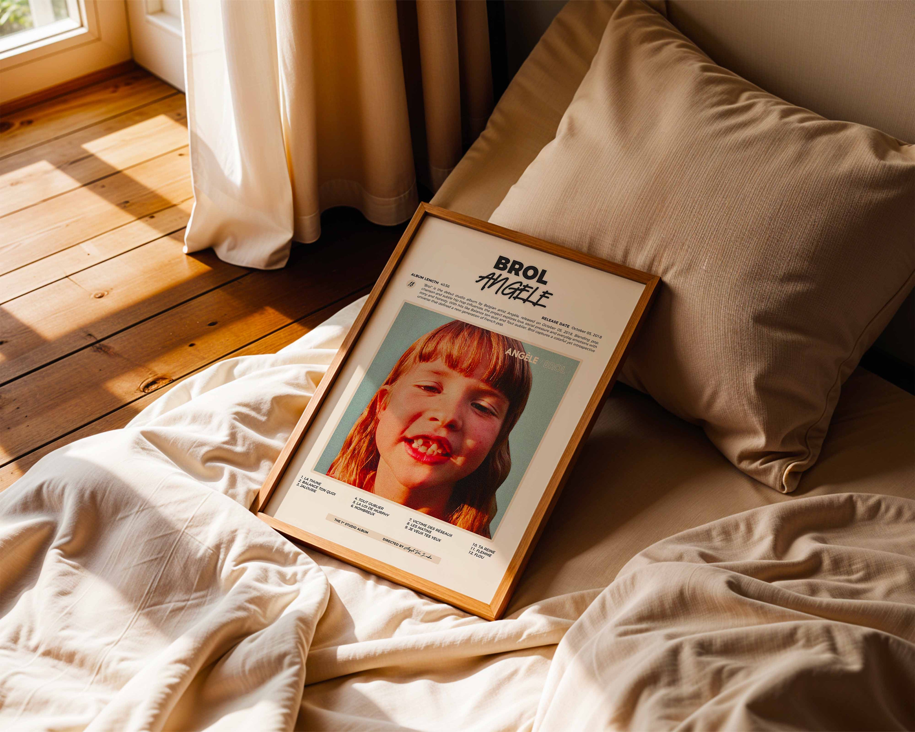 Poster minimaliste encadré de Angèle Brol posé sur un lit dans une chambre, idée cadeau fan de musique belge.