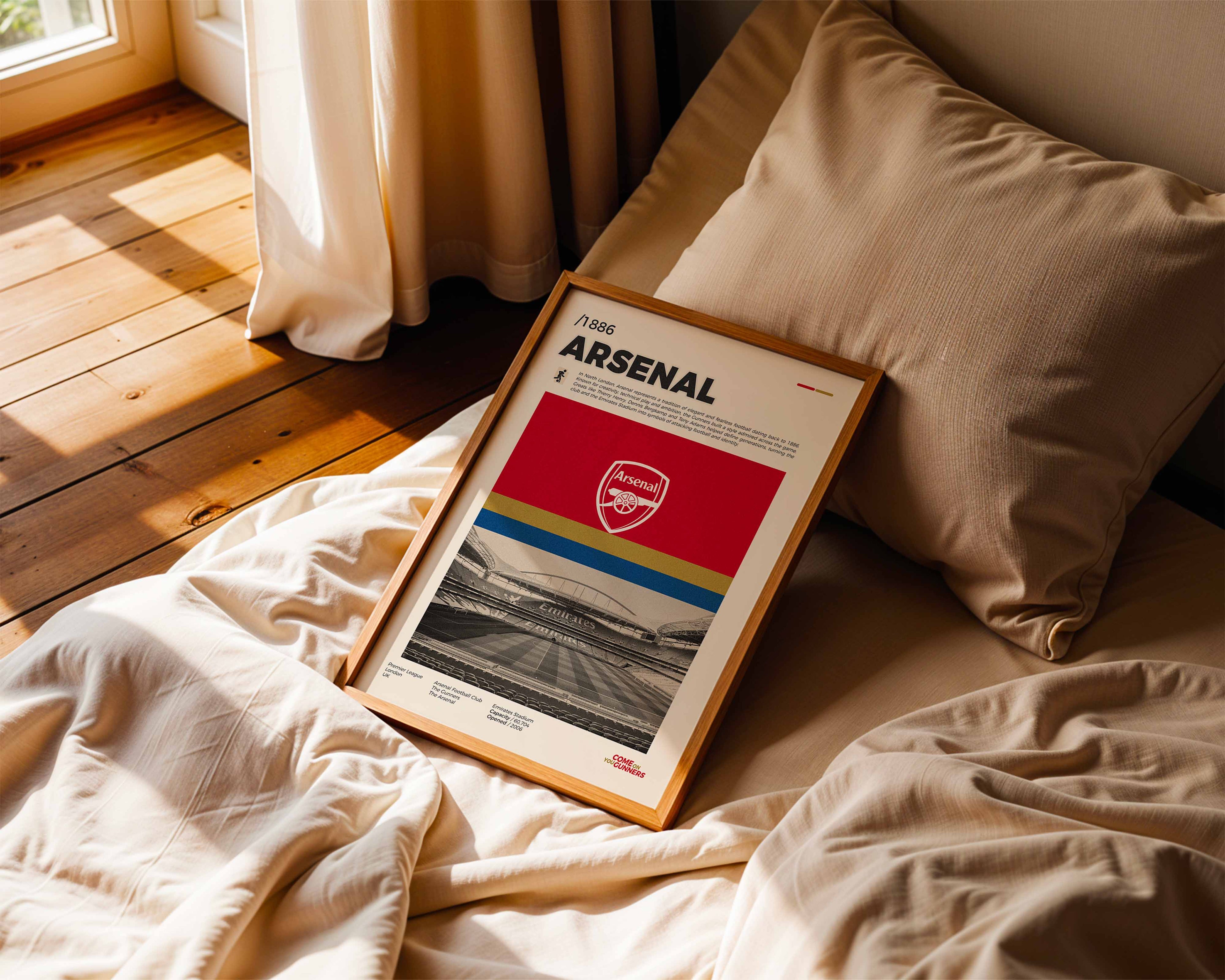 Poster minimaliste encadré d'Arsenal posé sur un lit dans une chambre, idée cadeau fan de football Gunners.