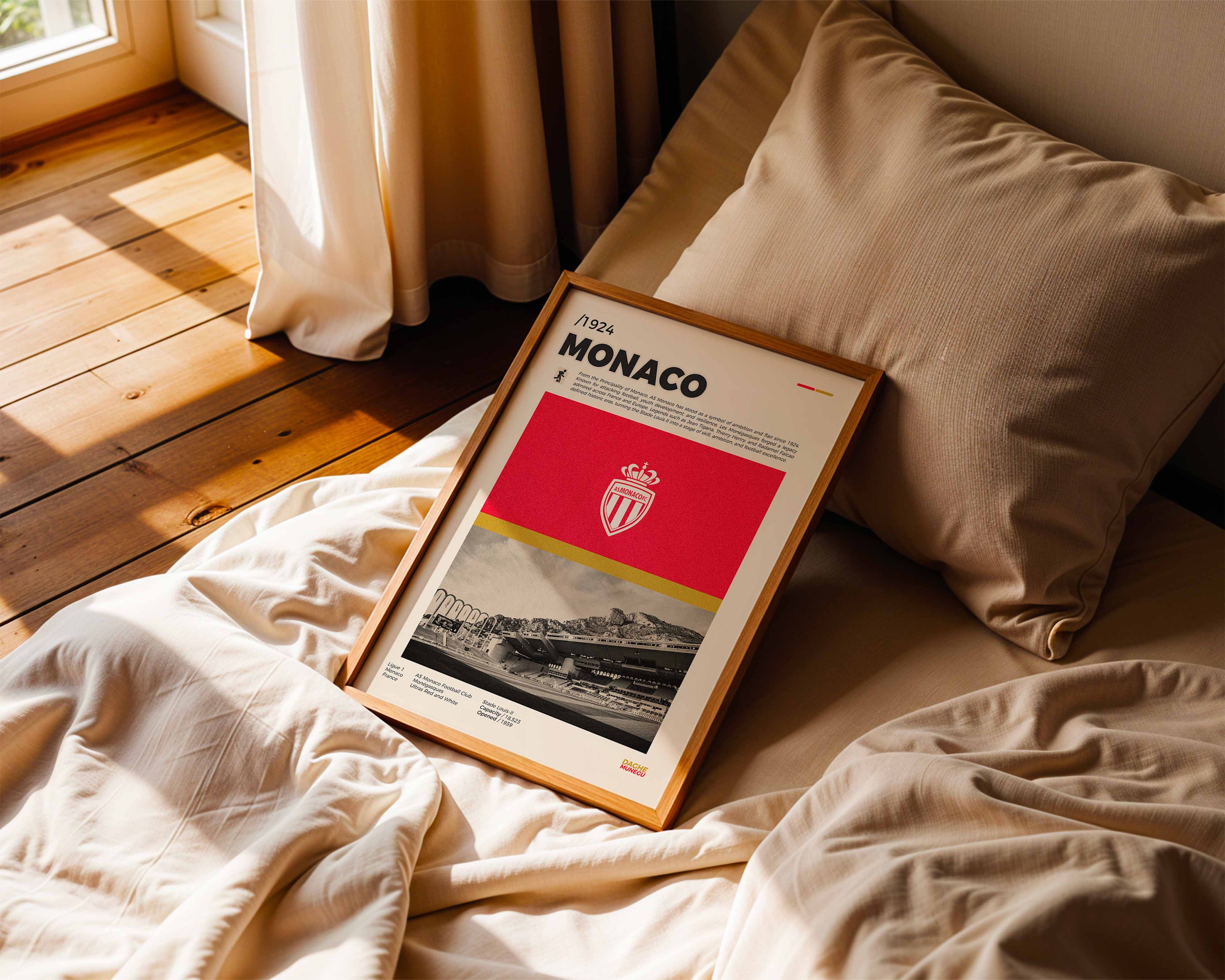 Poster minimaliste de l'AS Monaco posé sur un lit dans une chambre, idée cadeau fan du Stade Louis-II.