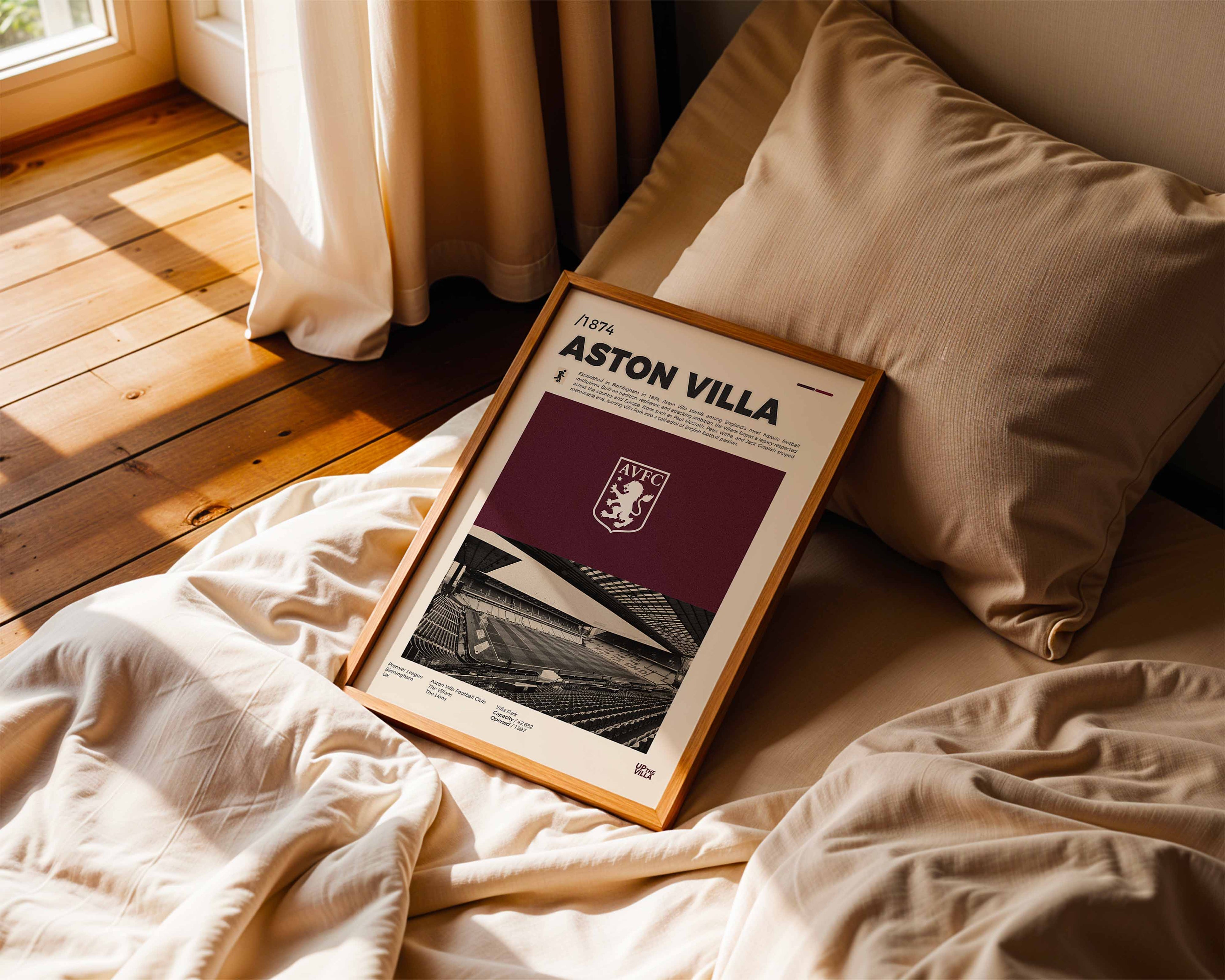 Poster minimaliste encadré de Aston Villa posé sur un lit dans une chambre, idée cadeau fan de Premier League.
