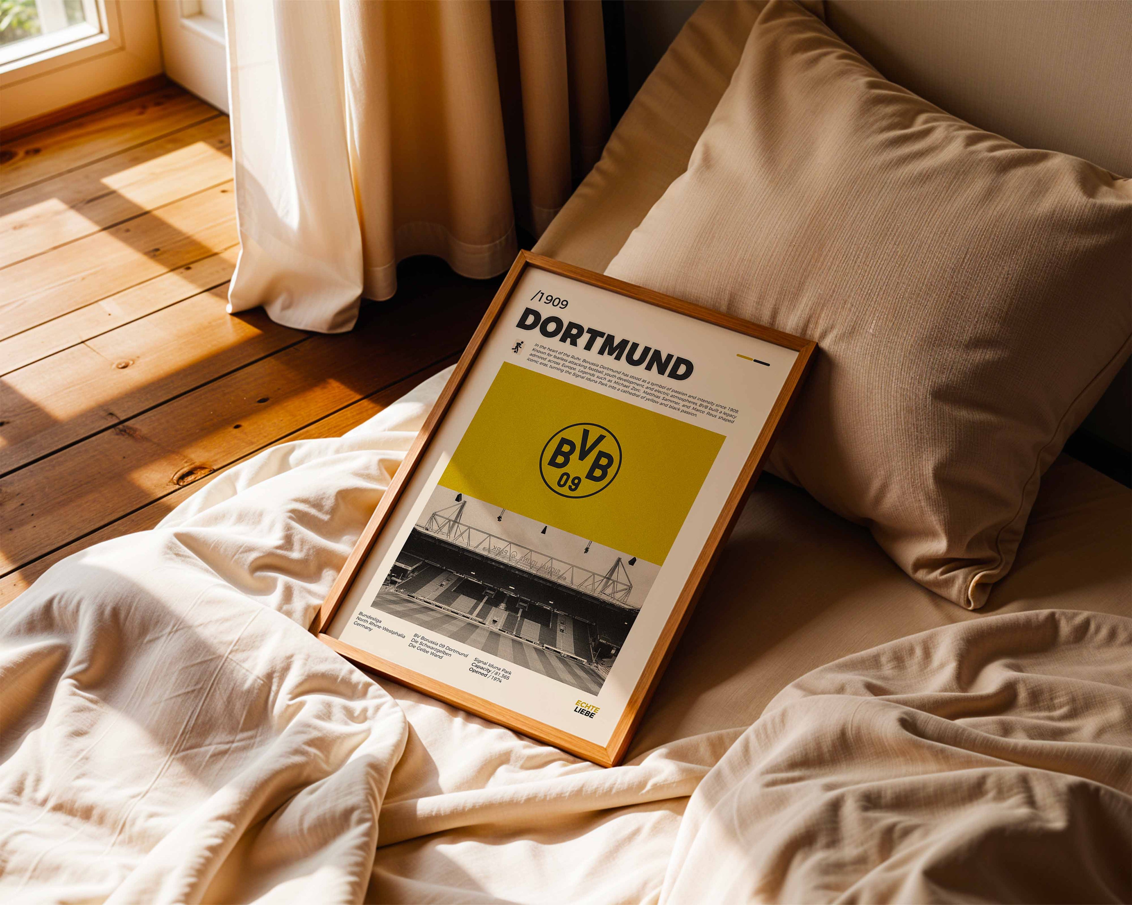 Poster minimaliste encadré de Dortmund posé sur un lit dans une chambre, idée cadeau fan du BVB.