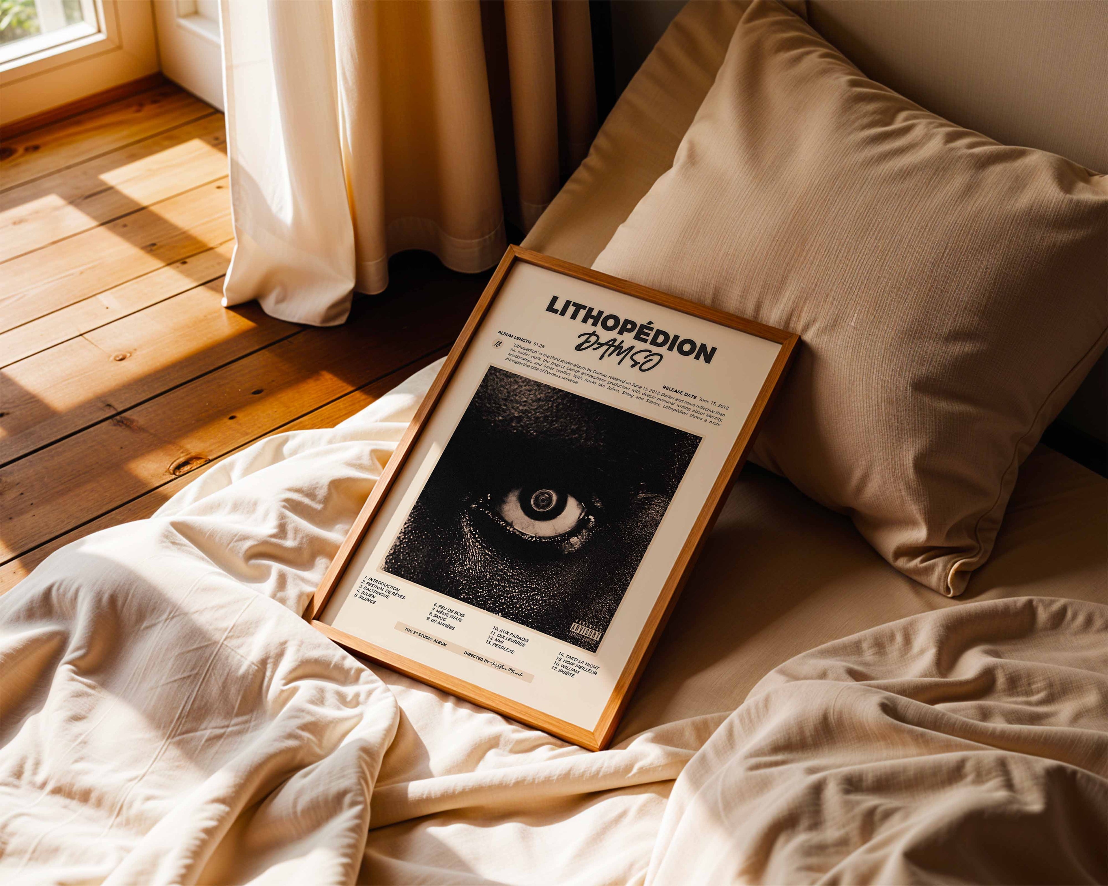 Poster minimaliste encadré de Damso Lithopedion posé sur un lit dans une chambre, idée cadeau fan de rap belge.
