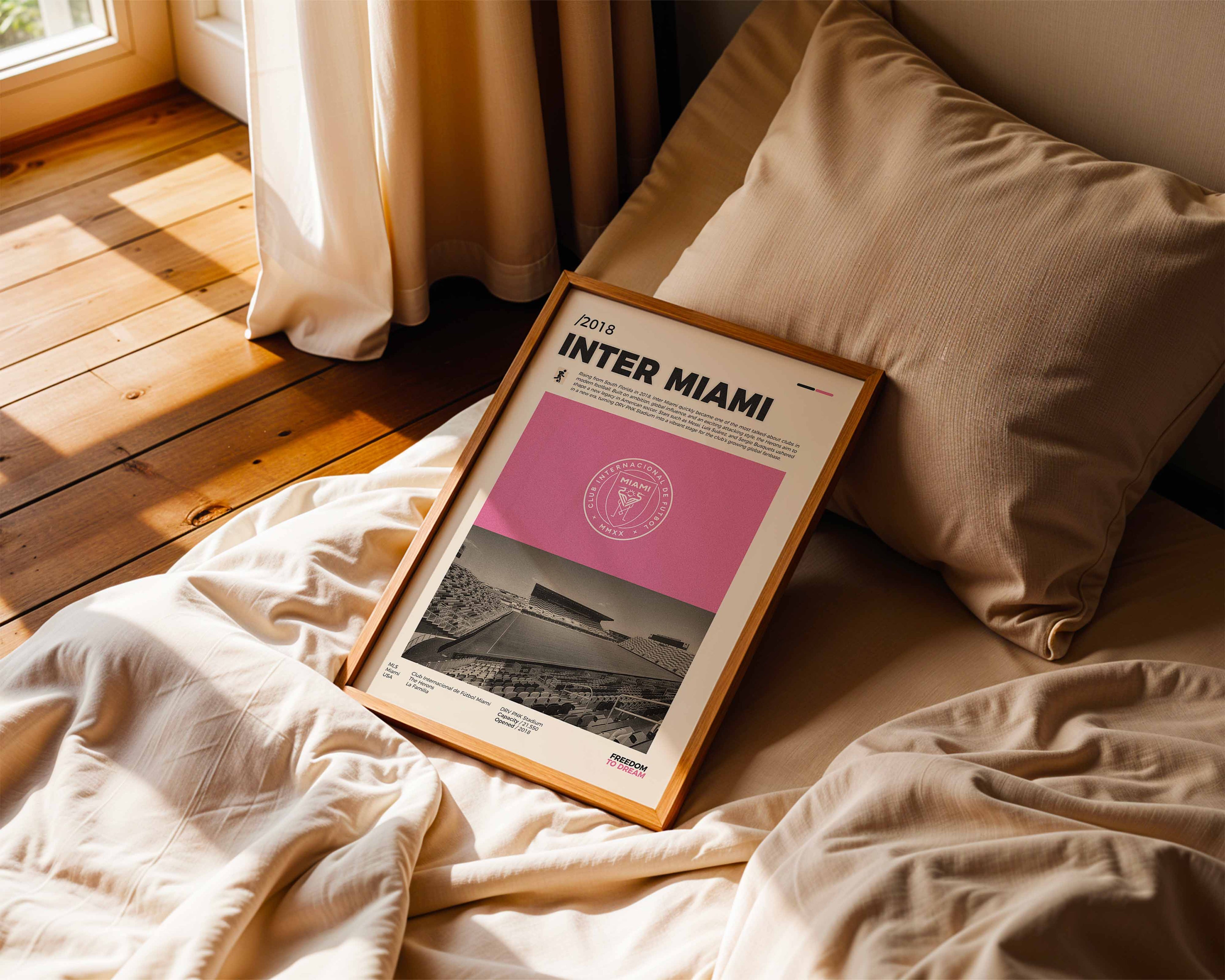 Poster minimaliste de l'Inter Miami posé sur un lit dans une chambre, idée cadeau fan du Chase Stadium.