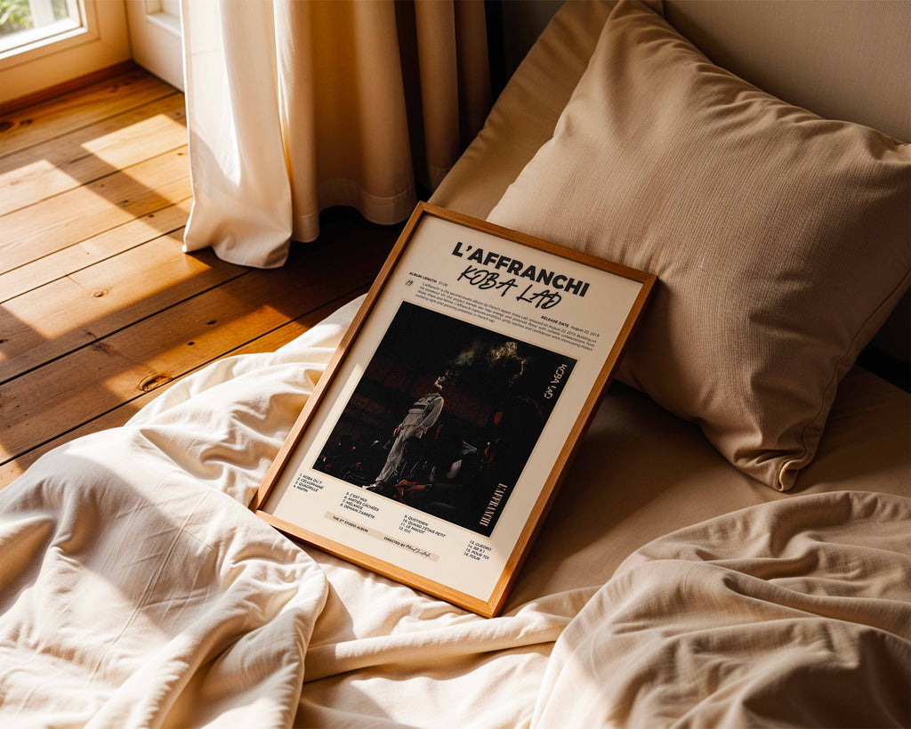 Poster minimaliste encadré de Koba LaD L'Affranchi posé sur un lit dans une chambre, idée cadeau fan du Bat 7.