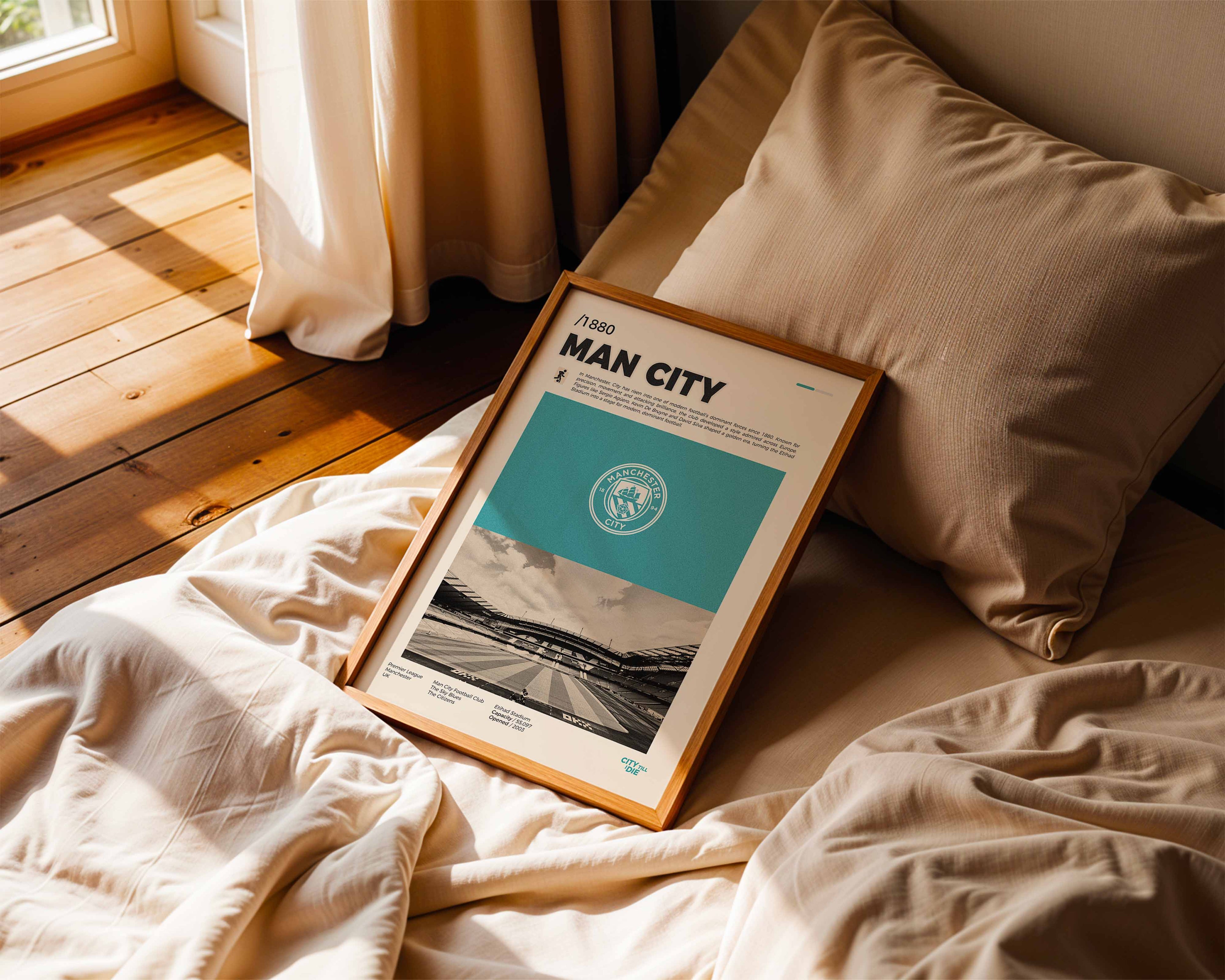Poster minimaliste encadré de Manchester City posé sur un lit dans une chambre, idée cadeau fan de football Manchester.
