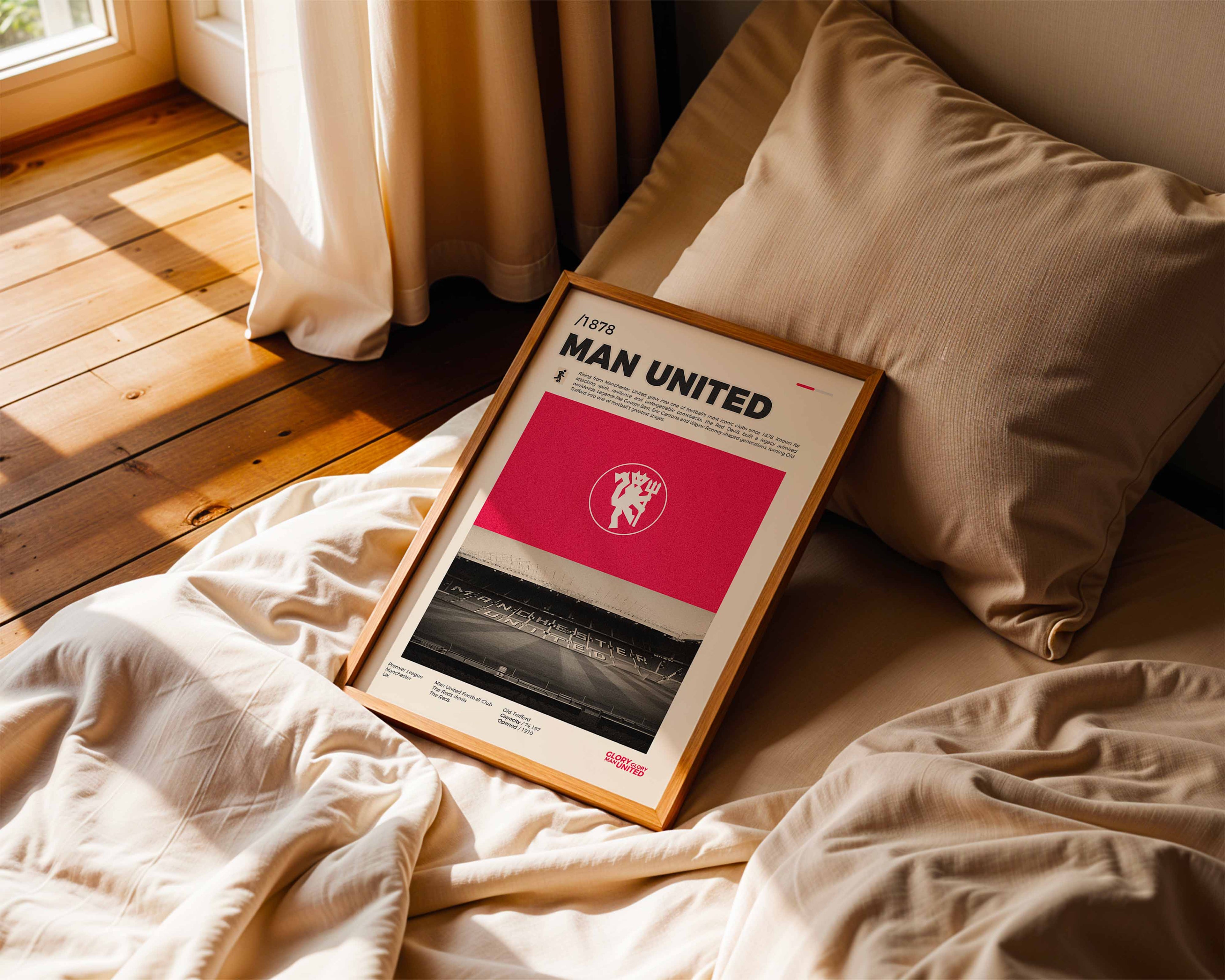 Poster minimaliste encadré de Manchester United posé sur un lit dans une chambre, idée cadeau fan de football Manchester.