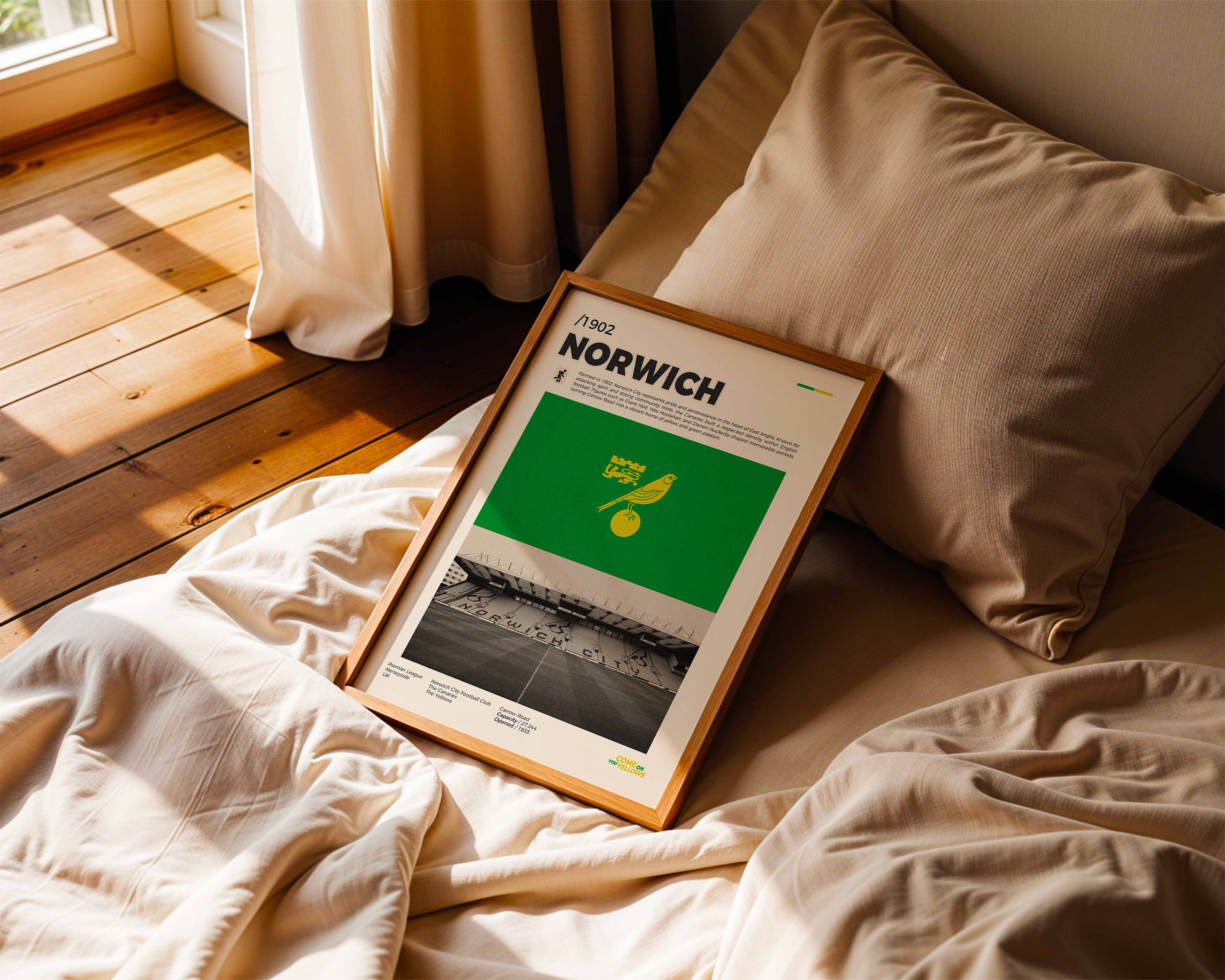 Poster minimaliste de Norwich City posé sur un lit dans une chambre, idée cadeau fan de Carrow Road.