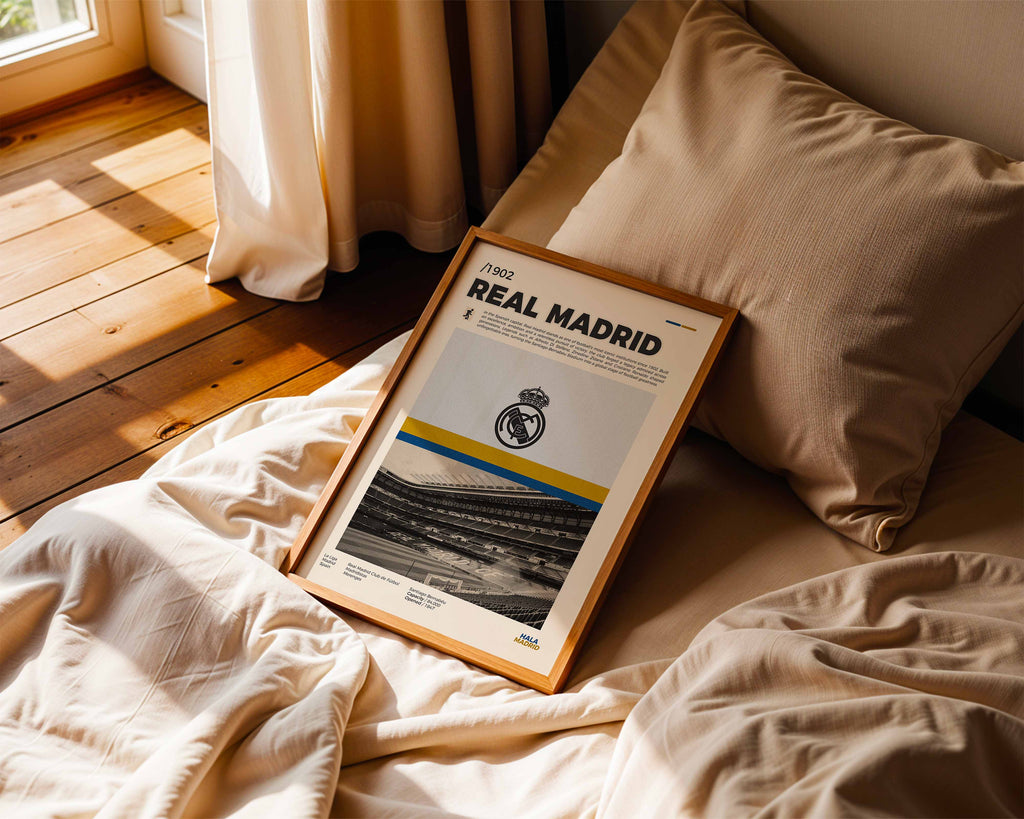 Poster minimaliste encadré du Real Madrid posé sur un lit dans une chambre, idée cadeau fan de football Madrid.