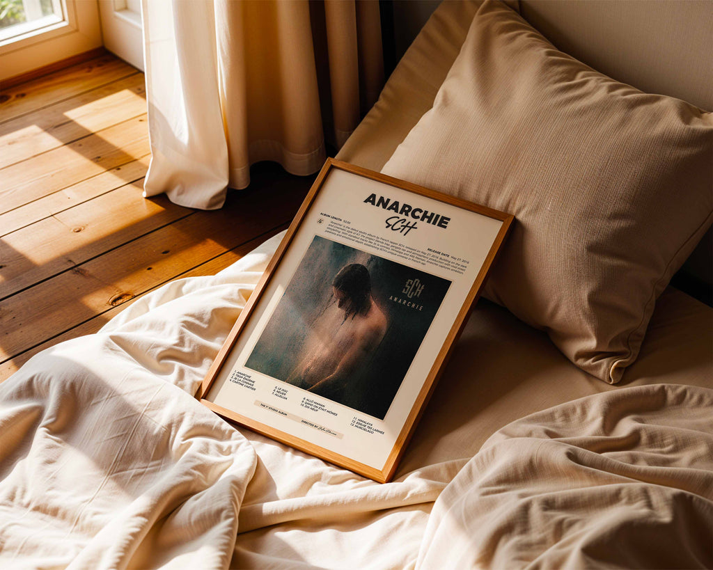 Poster minimaliste encadré de SCH Anarchie posé sur un lit dans une chambre, idée cadeau fan du S.