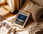 Poster minimaliste de Tottenham posé sur un lit dans une chambre, idée cadeau fan du Tottenham Hotspur Stadium.