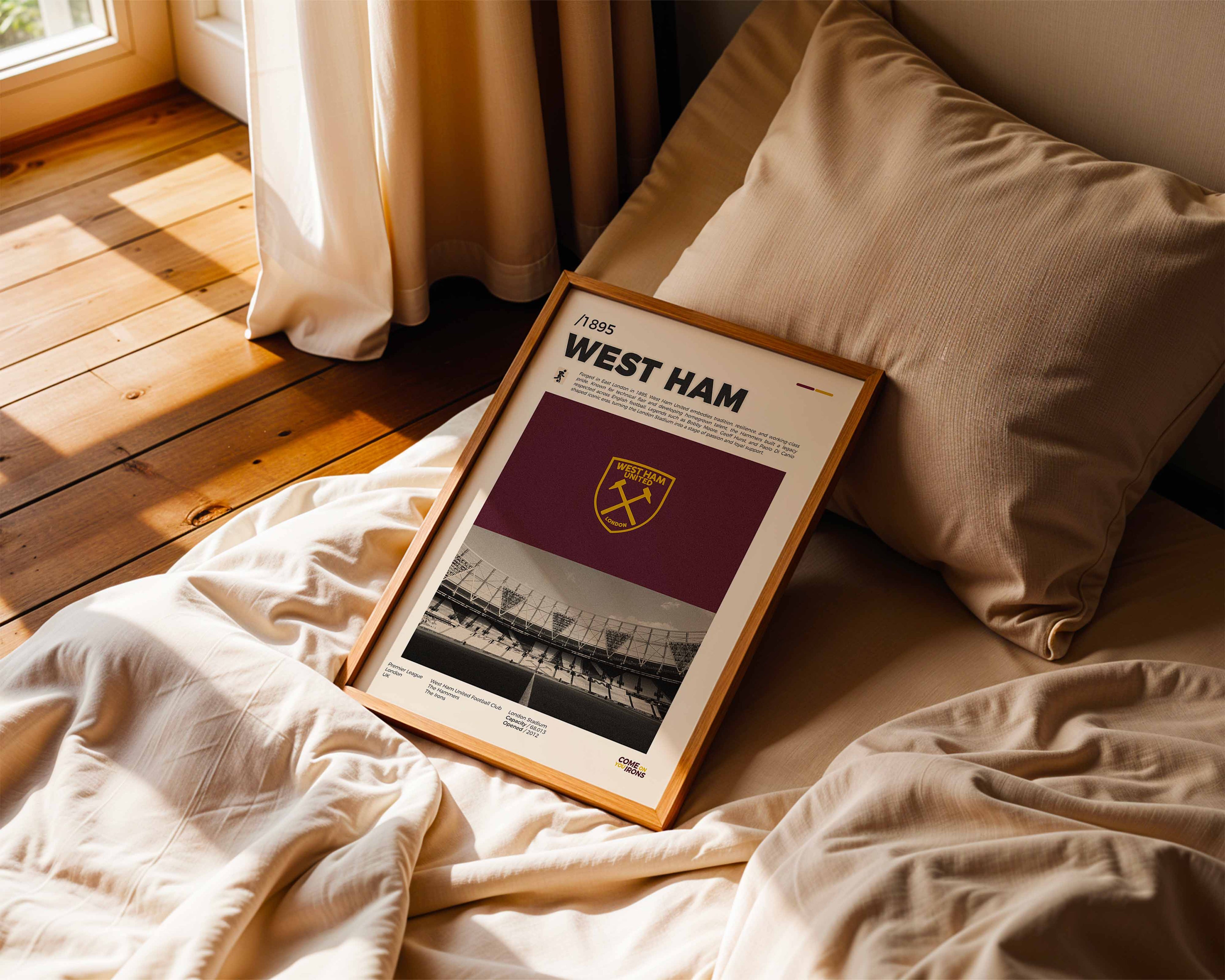 Poster minimaliste de West Ham posé sur un lit dans une chambre, idée cadeau fan du London Stadium.