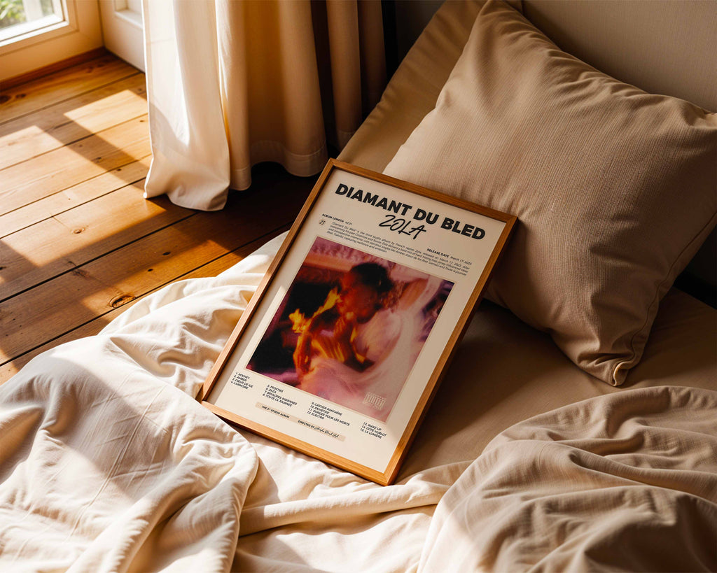 Poster minimaliste encadré de Zola Diamant du Bled posé sur un lit dans une chambre, idée cadeau fan de Zola.