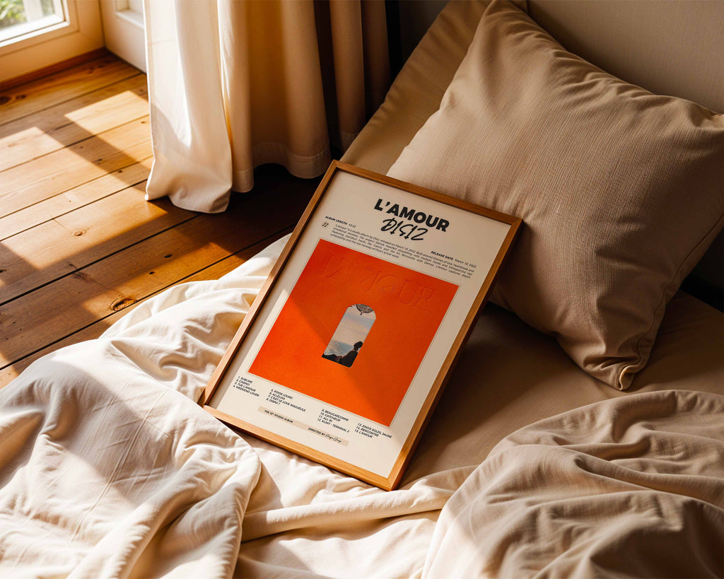 Poster album Disiz posé sur un lit dans une chambre à l'ambiance chaleureuse et cocooning, cadeau parfait pour fan de l'album L'Amour.